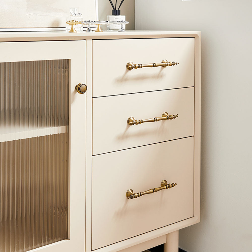 Bronze ornate brass cabinet pull and knob, shown from one angle installed on cabinetry in context