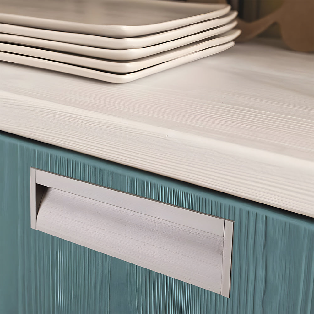Silver aluminum recessed cabinet pull with 160 mm hole centers installed horizontally on a teal drawer
