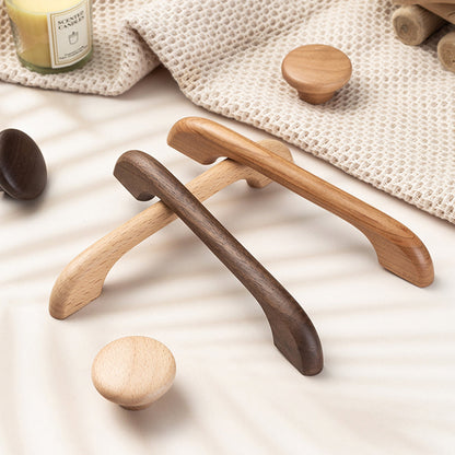 Curved solid wood cabinet pull with a matching round knob, grouped on a light surface to compare lengths and profiles