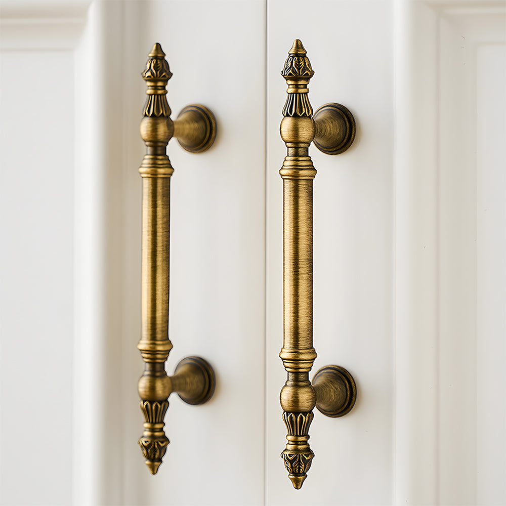 Ornate european brass cabinet pull and round knobs, displayed from the side installed on cabinetry in context