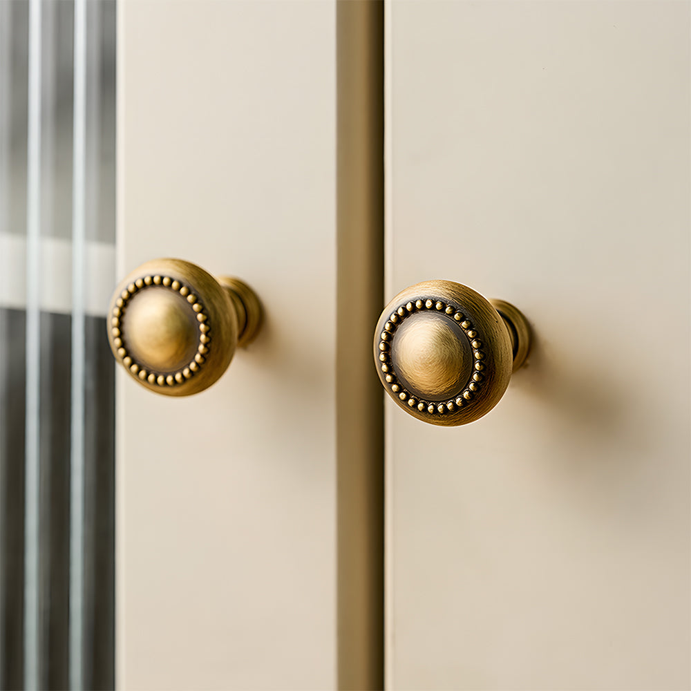 Ornate european brass cabinet pull and round knobs, presented in another view installed on cabinetry in context