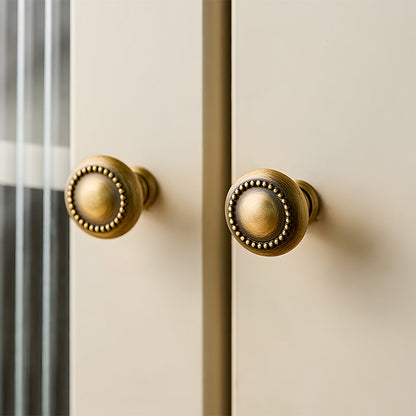 Ornate european brass cabinet pull and round knobs, presented in another view installed on cabinetry in context