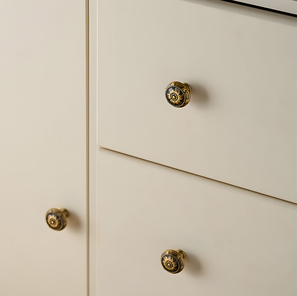 Ornate european brass cabinet pull and round knobs, shown clearly mounted on a finished cabinet front