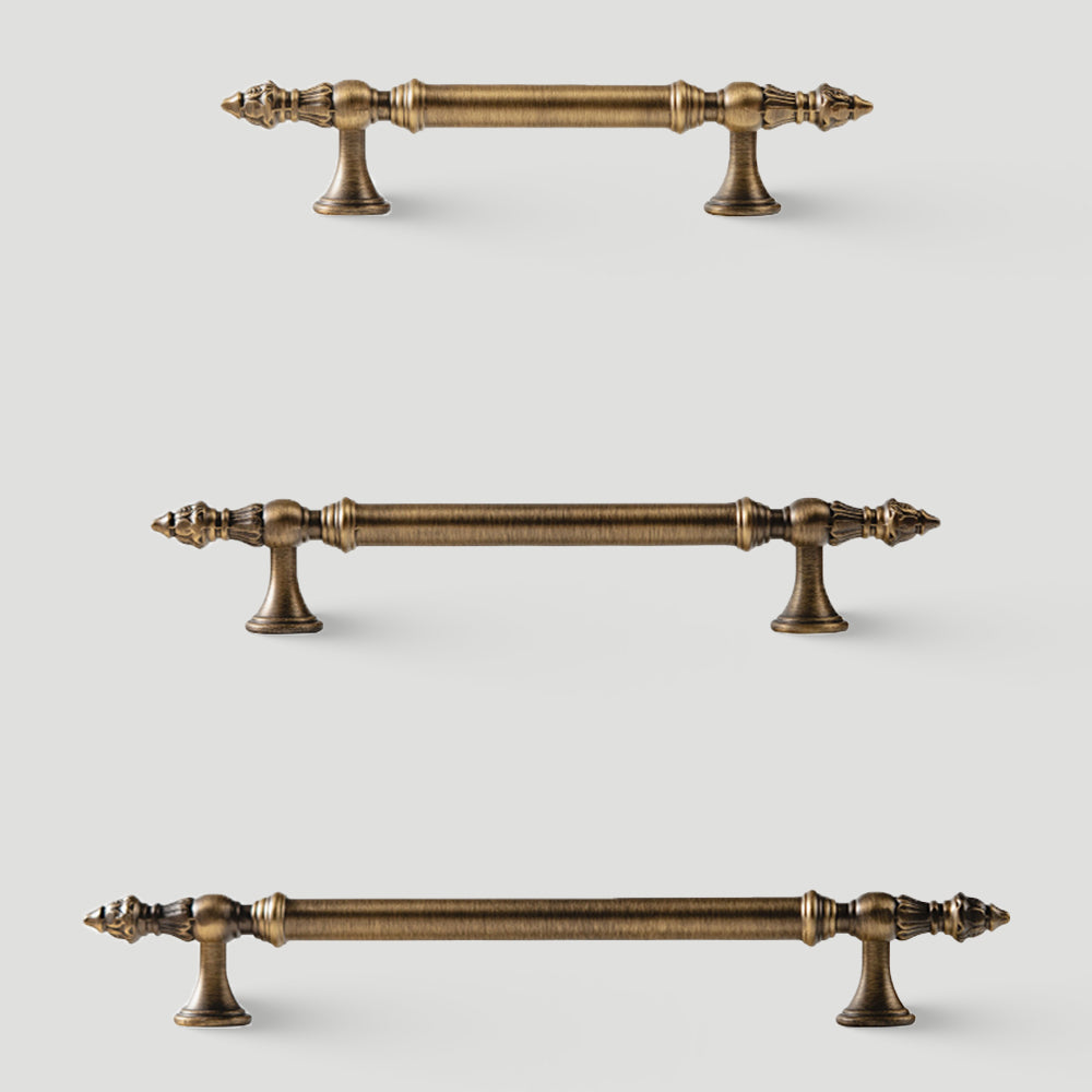 Ornate european brass cabinet pull and round knobs, shown at close range with related hardware in one display