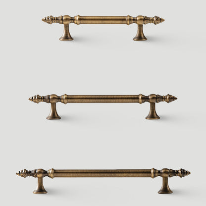 Ornate european brass cabinet pull and round knobs, shown at close range with related hardware in one display