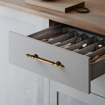 Ornate european brass cabinet pull and round knobs, shown clearly installed on cabinetry in context
