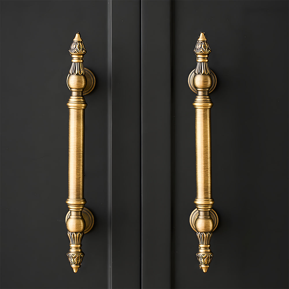 Ornate european brass cabinet pull and round knobs, pictured in one view installed on cabinetry in context