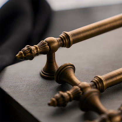 Ornate european brass cabinet pull and round knobs, shown from one angle in an installed cabinet close-up