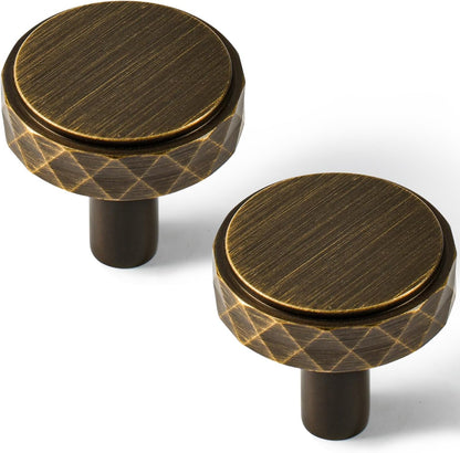 Faceted brass cabinet pull and round knob, shown clearly in an installed cabinet close-up