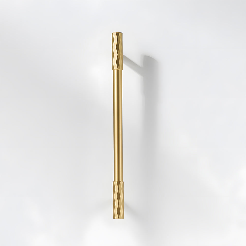 Gold faceted brass cabinet pull and round knob, shown from one angle on a clean neutral background