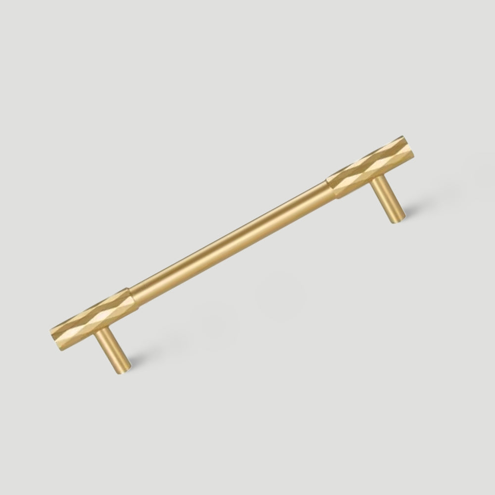Gold faceted brass cabinet pull and round knob, presented for reference on a clean neutral background