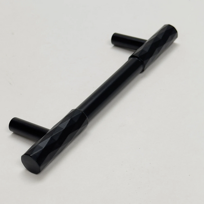 Black faceted brass cabinet pull and round knob, shown clearly with its shape and finish visible