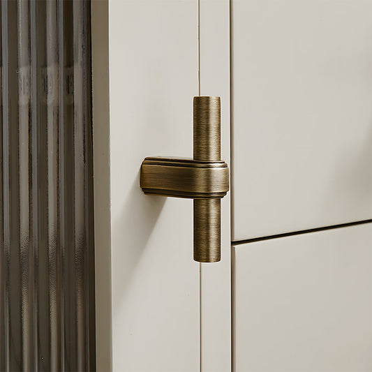 French brass round bar cabinet pull with block mounts, shown from one angle in an installed cabinet close-up