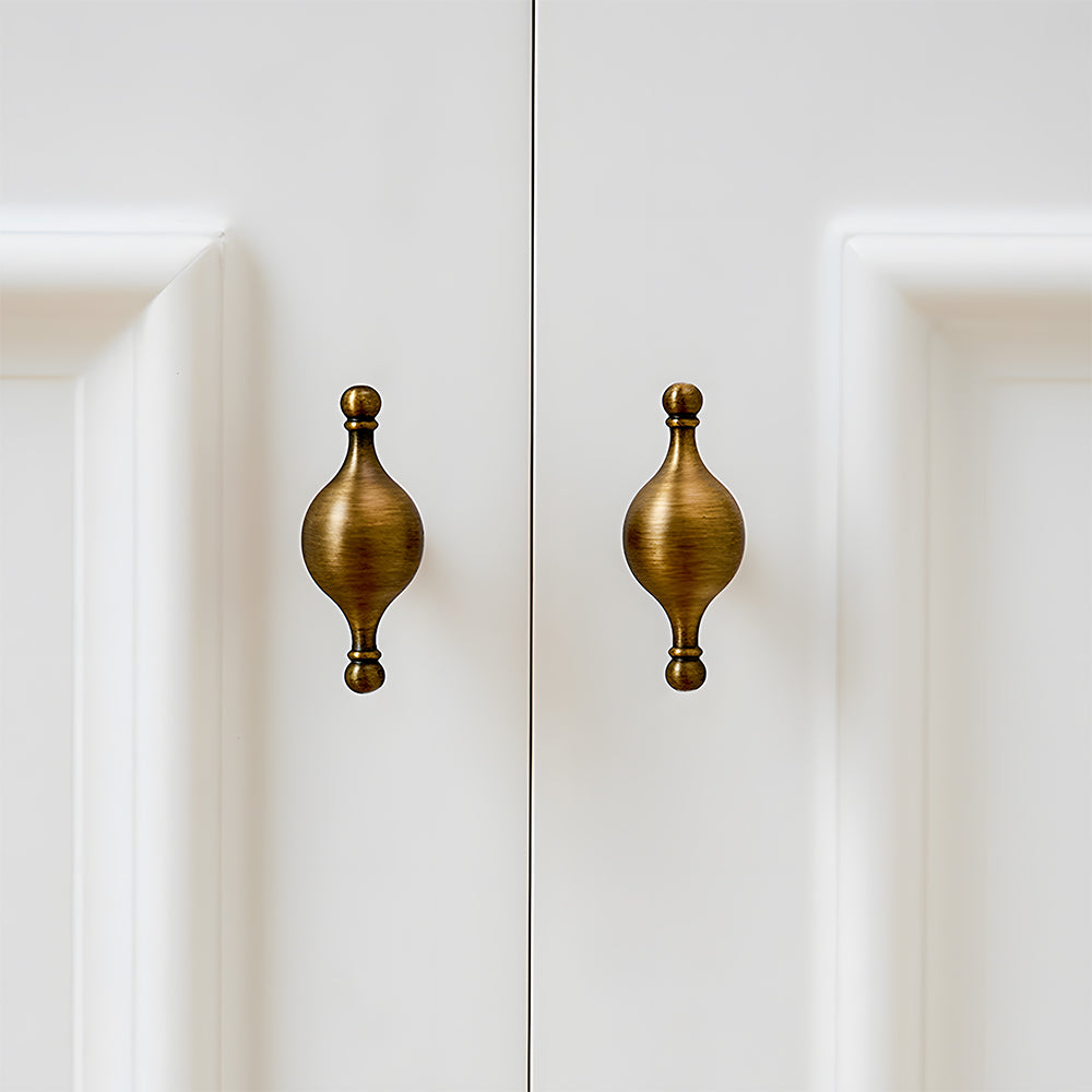 French retro turned brass cabinet pull and spindle knob, presented for reference installed on cabinetry in context