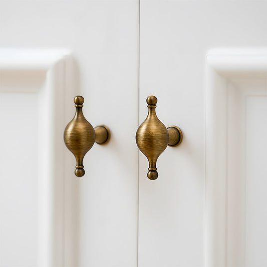 French retro turned brass cabinet pull and spindle knob, shown clearly mounted on a finished cabinet front