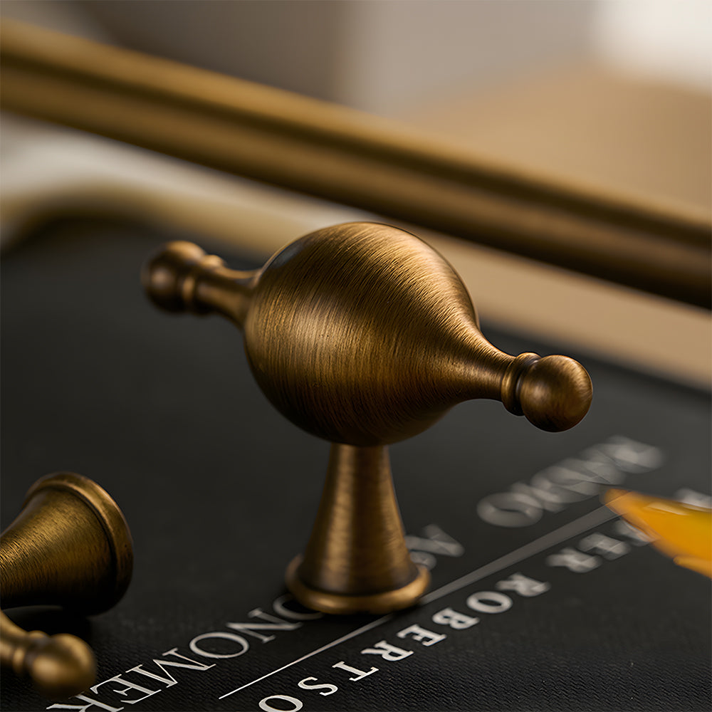 French retro turned brass cabinet pull and spindle knob, presented for reference in an installed cabinet close-up