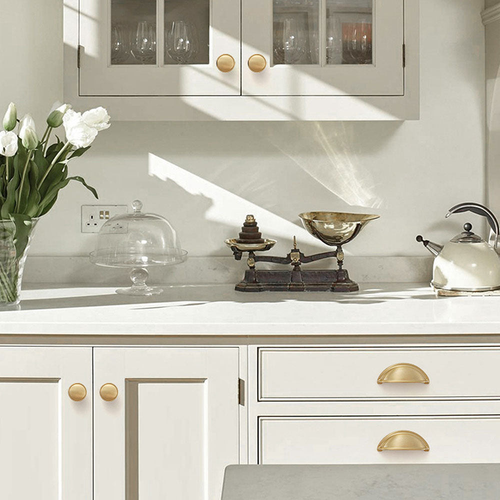 Half-round brass cabinet cup pull, shown clearly installed on cabinetry in context