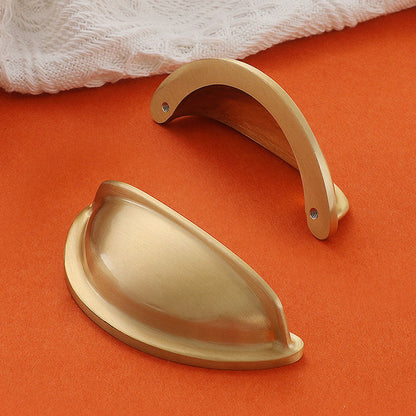 Half-round brass cabinet cup pull, shown from one angle with its construction and finish visible