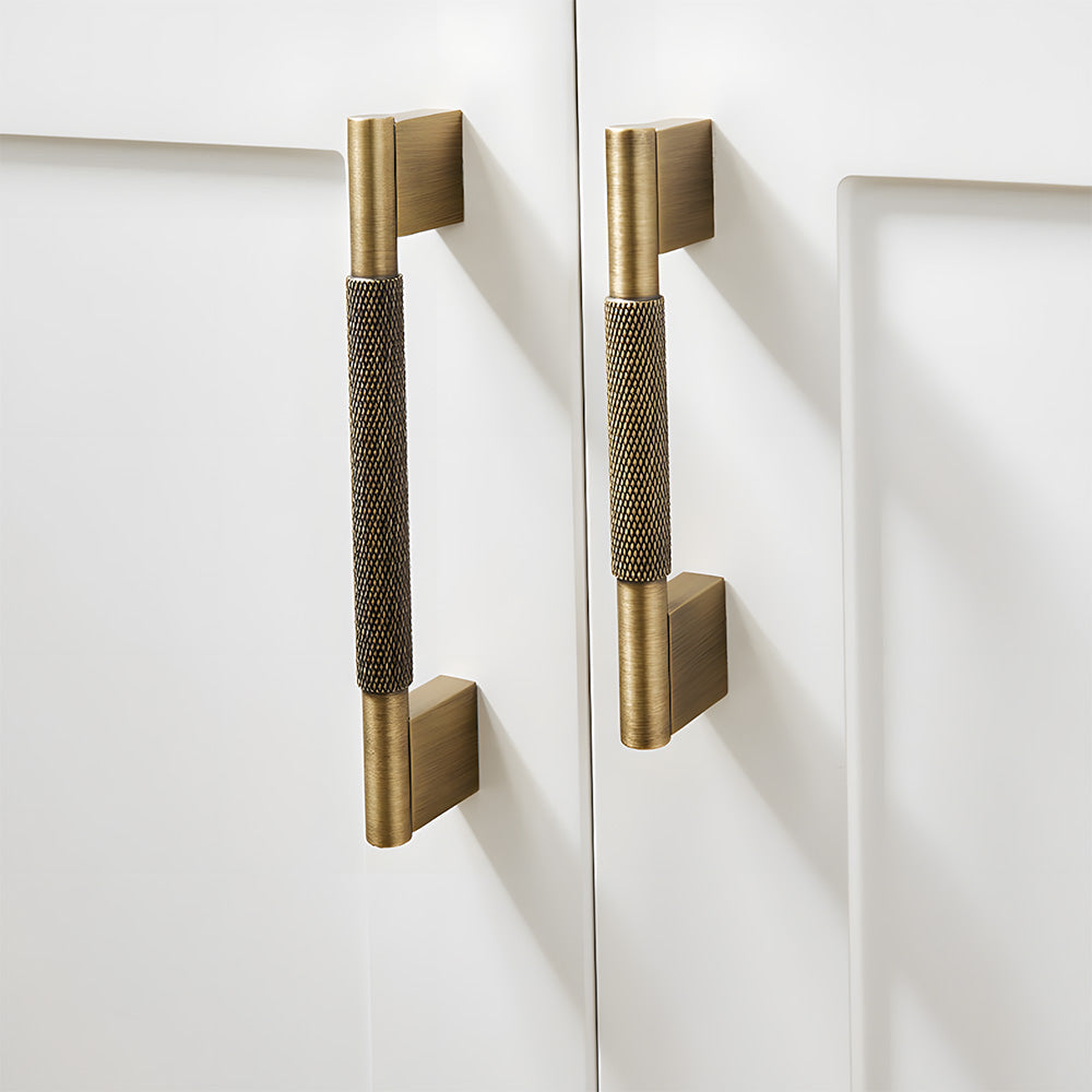 Knurled brass cabinet pull with rectangular mounts and knob, shown clearly mounted on a finished cabinet front