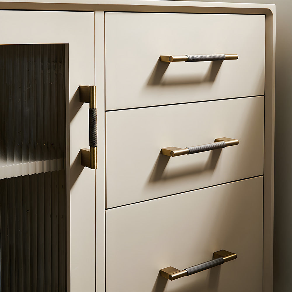 Knurled brass cabinet pull with rectangular mounts and knob, shown from one angle installed on cabinetry in context