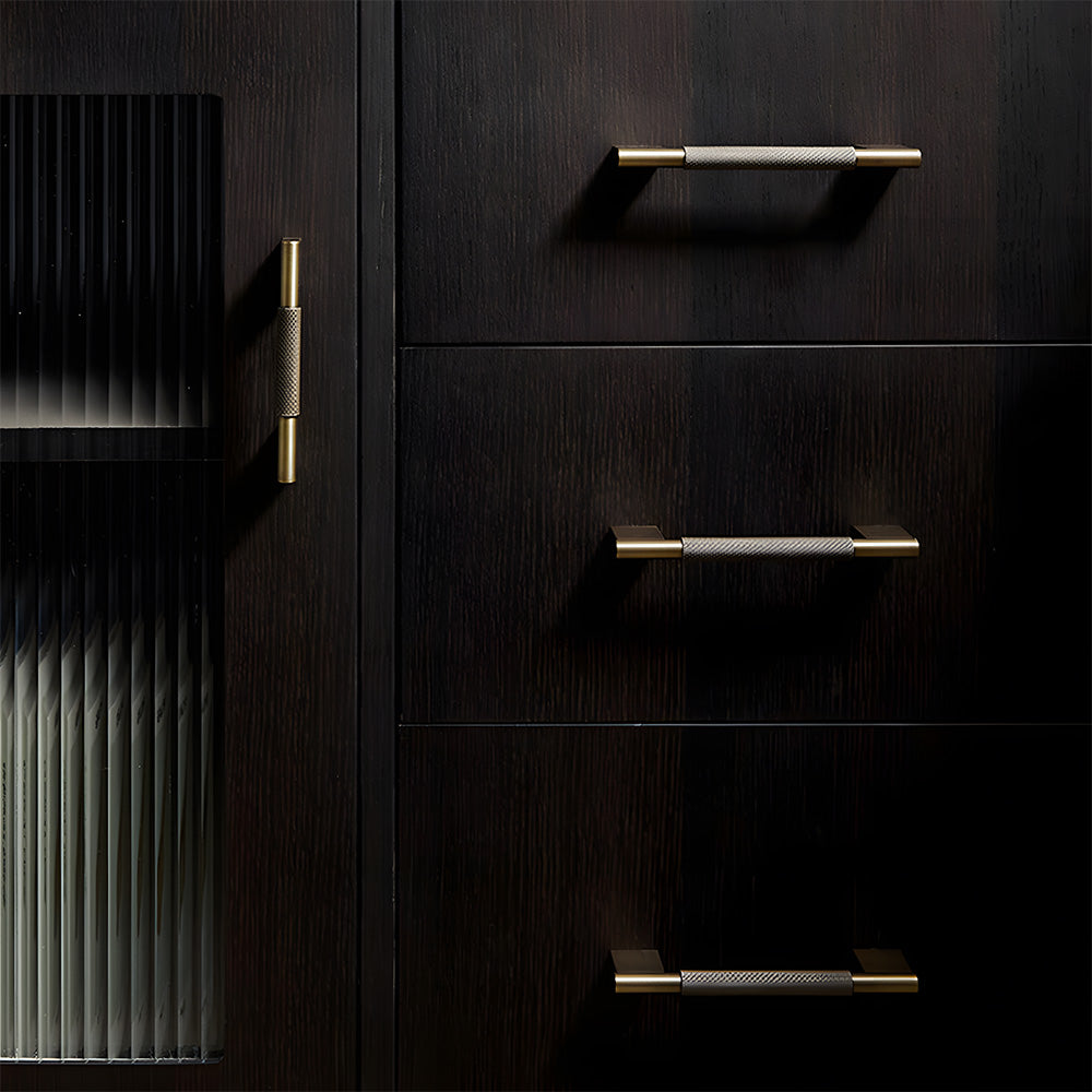 Knurled brass cabinet pull with rectangular mounts and knob, shown in a focused view installed on cabinetry in context