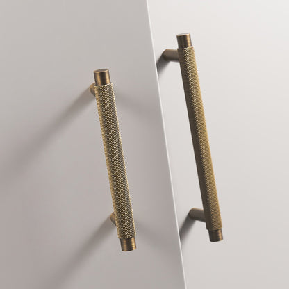 Antique bronze knurled T-bar cabinet pull, shown at close range in an installed cabinet close-up