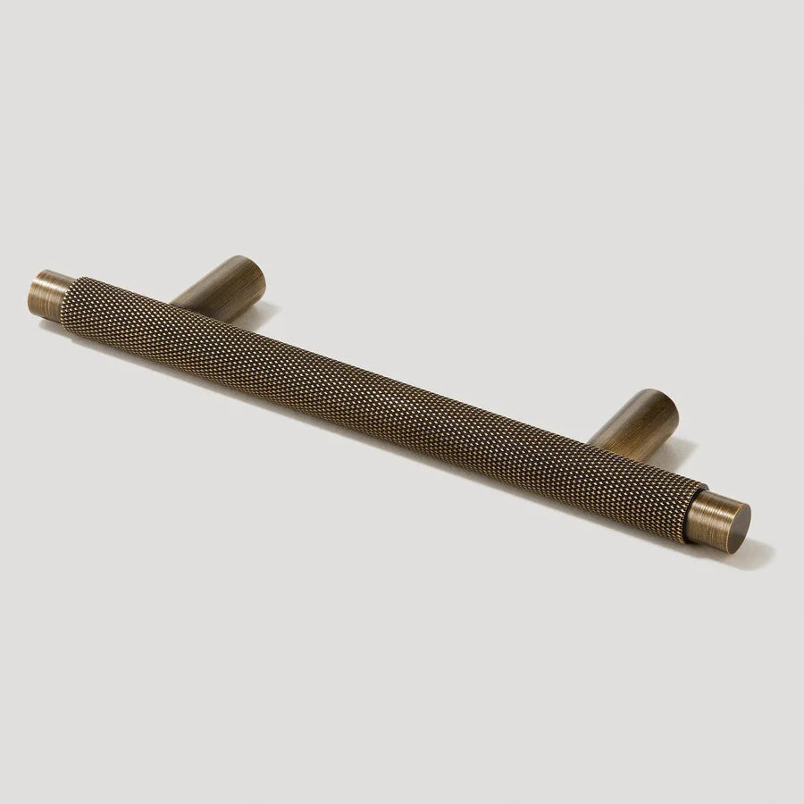 Antique bronze knurled T-bar cabinet pull, shown clearly with its shape and finish visible