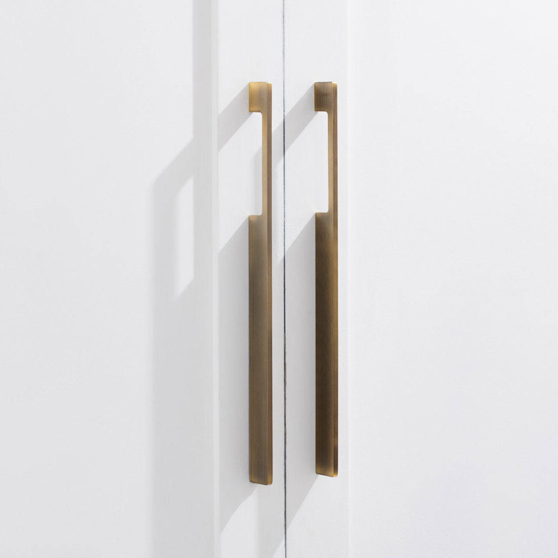 Bronze slim rectangular aluminum cabinet pull, shown clearly in an installed cabinet close-up