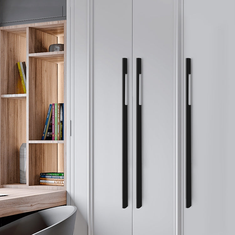 Black slim rectangular aluminum cabinet pull, pictured in one view mounted on a finished cabinet front