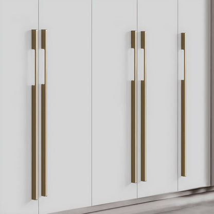 Bronze slim rectangular aluminum cabinet pull, shown at close range mounted on a finished cabinet front