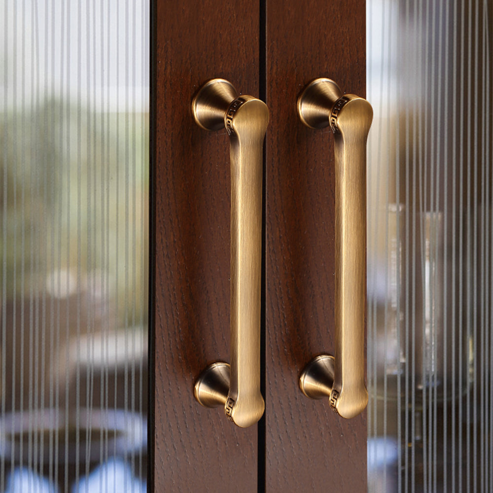 Traditional cabinet pull with flared mounts and knob, shown clearly in an installed cabinet close-up