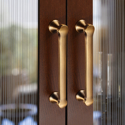 Traditional cabinet pull with flared mounts and knob, shown clearly in an installed cabinet close-up