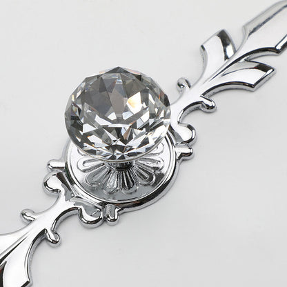 Faceted crystal cabinet knob with ornate leaf backplate, shown clearly with its construction and finish visible