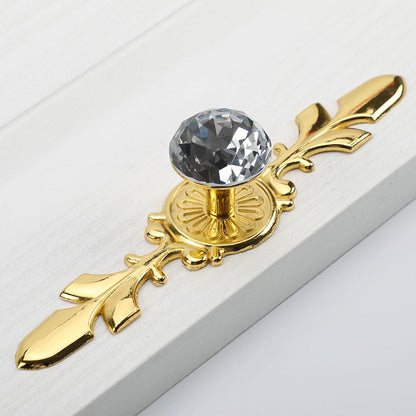 Faceted crystal cabinet knob with ornate leaf backplate, presented for reference on a clean neutral background