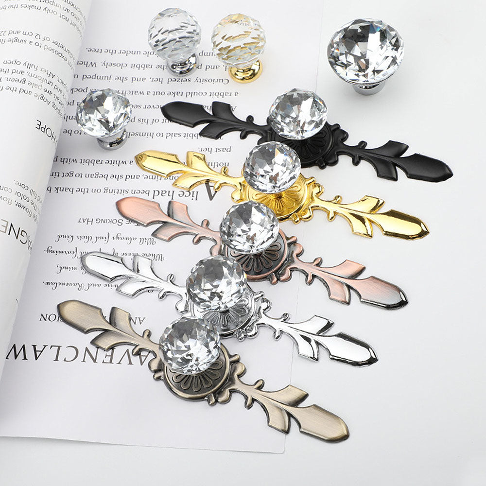 Faceted crystal cabinet knob with ornate leaf backplate, shown clearly as a color and finish lineup