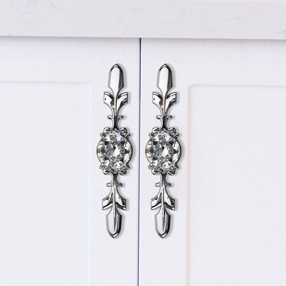 Faceted crystal cabinet knob with ornate leaf backplate, shown clearly in an installed cabinet close-up
