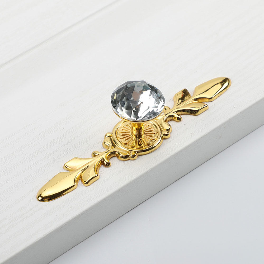 Faceted crystal cabinet knob with ornate leaf backplate, pictured in one view on a clean neutral background