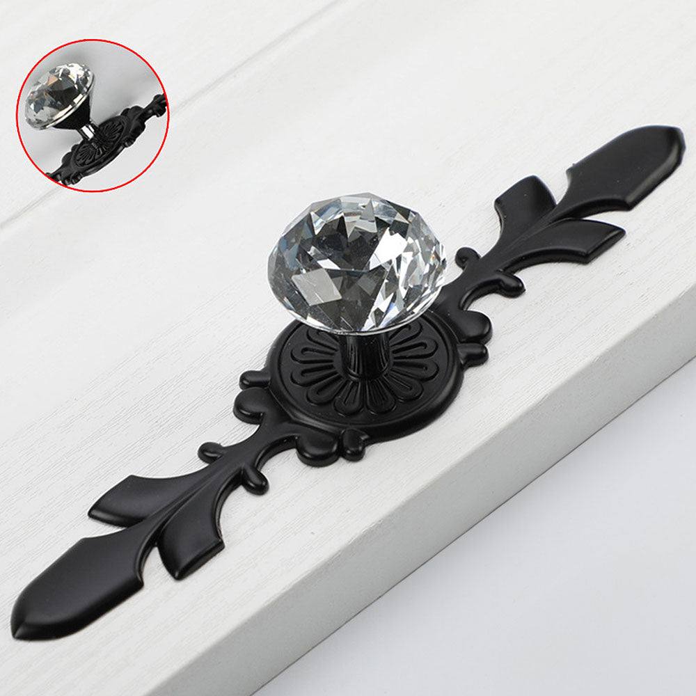 Faceted crystal cabinet knob with ornate leaf backplate, shown from one angle with its construction and finish visible