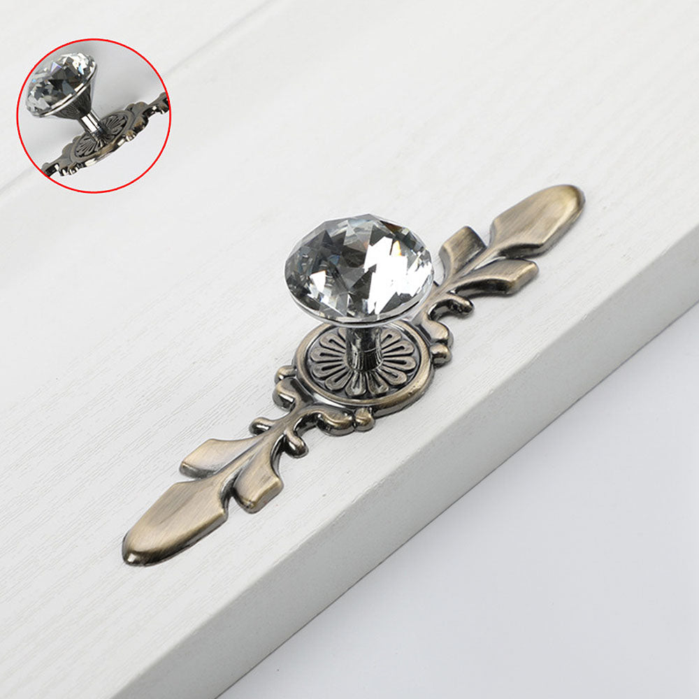 Faceted crystal cabinet knob with ornate leaf backplate, pictured in one view with its construction and finish visible