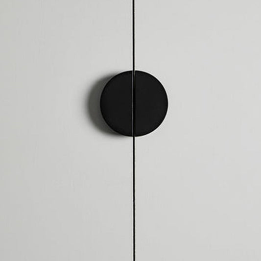 Black half-moon cabinet edge pull, shown clearly in an installed cabinet close-up