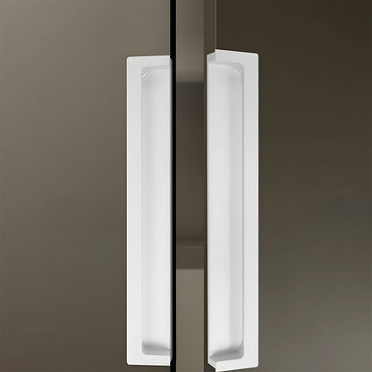 White concealed slotted cabinet pull, shown from one angle in an installed cabinet close-up