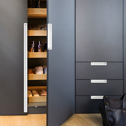 White concealed slotted cabinet pull, shown in a focused view installed on cabinetry in context