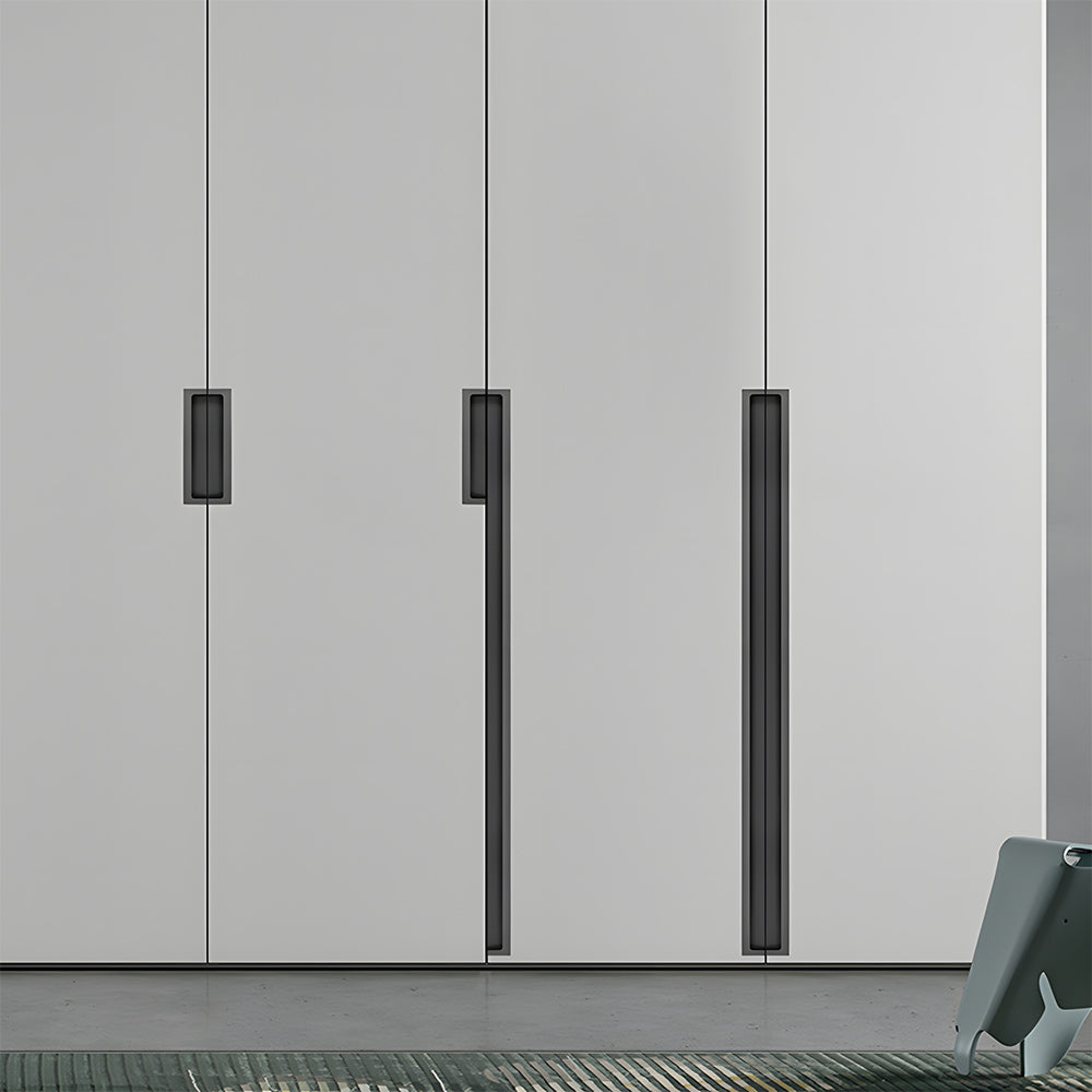 Black concealed slotted cabinet pull, pictured in one view installed on cabinetry in context