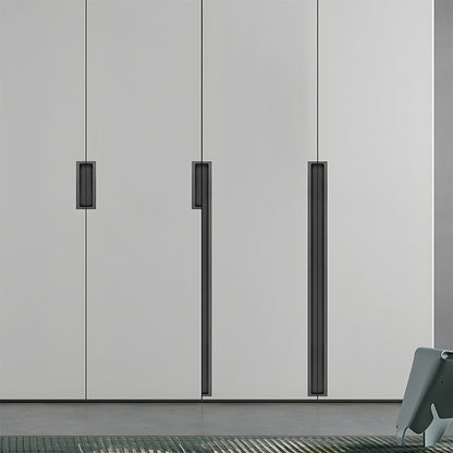 Black concealed slotted cabinet pull, pictured in one view installed on cabinetry in context