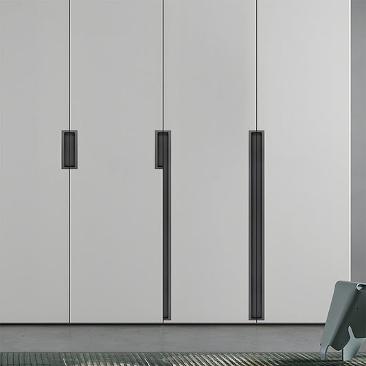 Black concealed slotted cabinet pull, pictured in one view installed on cabinetry in context