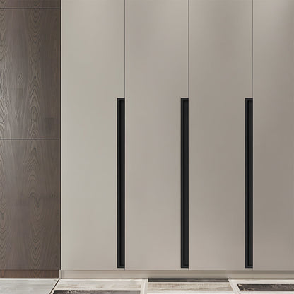 Black concealed slotted cabinet pull, presented for reference installed on cabinetry in context