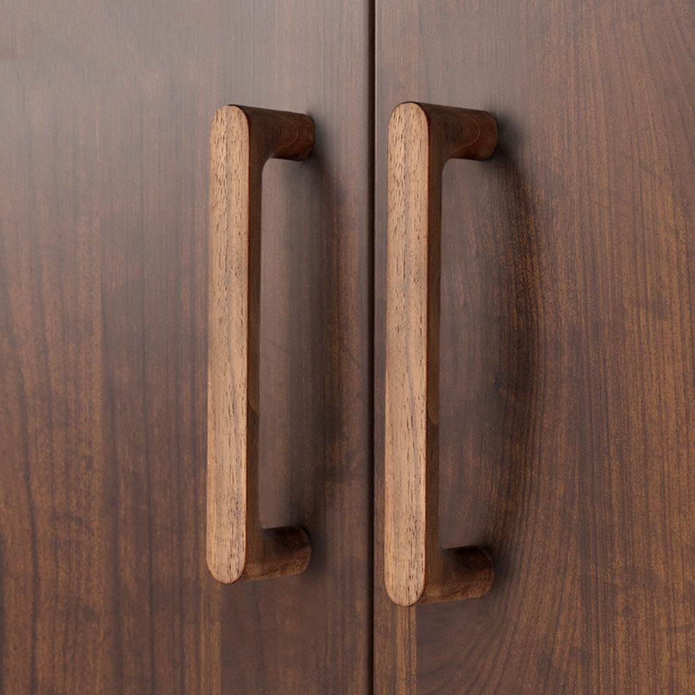 Rounded wood cabinet pull in black walnut, installed on paired cabinet doors in a close view