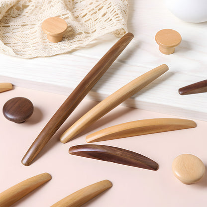 Natural wood cabinet pull with a tapered leaf-shaped profile, arranged together from an overhead angle for comparison