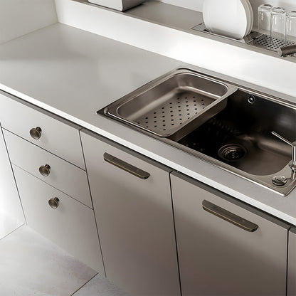 Recessed brass drawer pull with matching cabinet knob, presented for reference installed on cabinetry in context