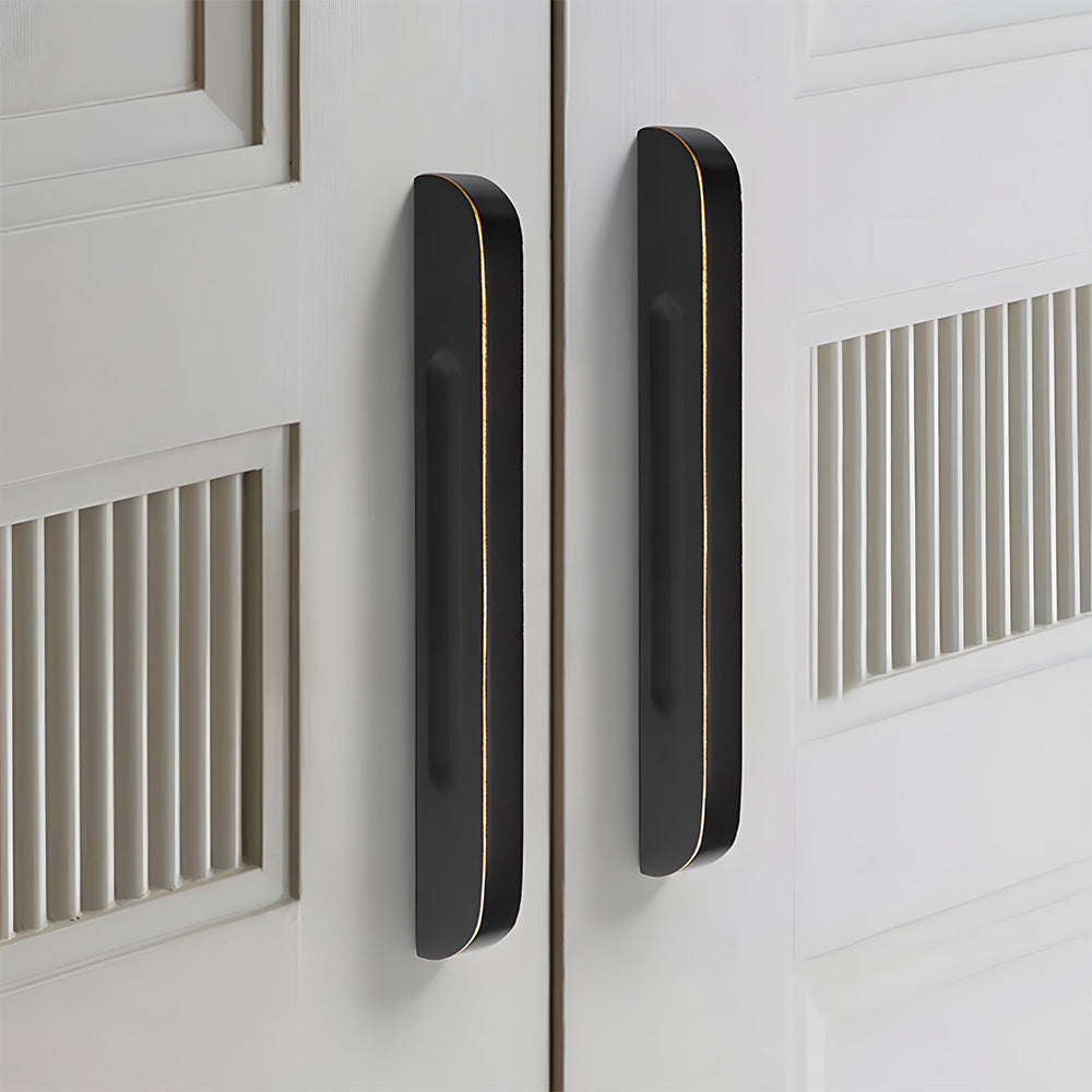Recessed brass drawer pull with matching cabinet knob, shown in a focused view installed on cabinetry in context